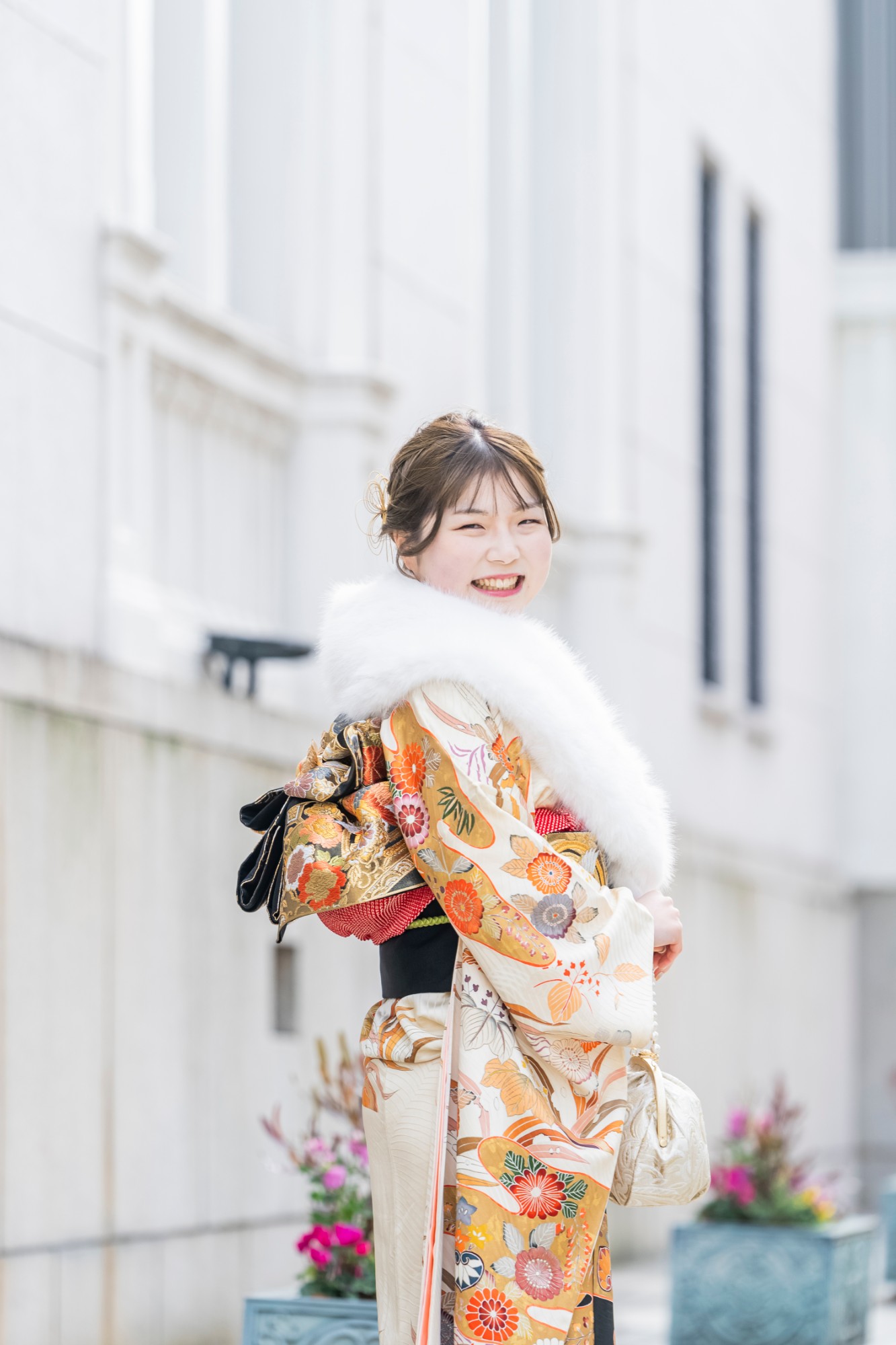 振り返って笑顔を見せる、白いファーと振袖姿の女性