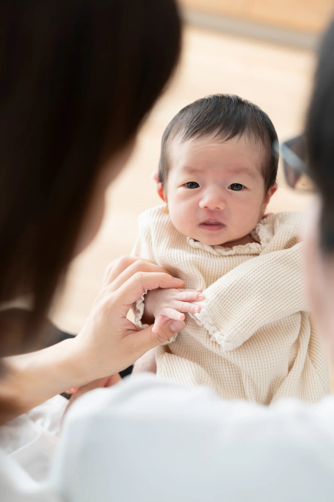 両親に見守られる赤ちゃんのアップ