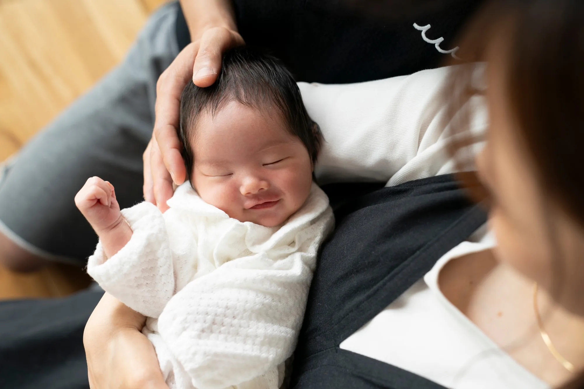 赤ちゃんを抱き、微笑む父親